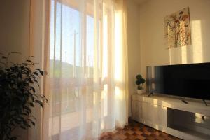 San Mauro di SalineCase VR Holiday Appartamenti Bellavista的一间带电视和窗户的客厅