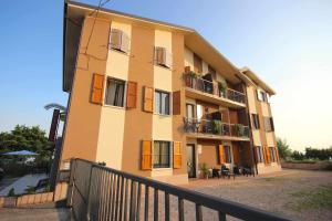 San Mauro di SalineCase VR Holiday Appartamenti Bellavista的黄色的建筑,设有带桌椅的阳台