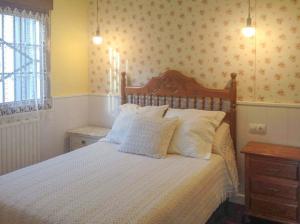 卡瑞纳Casa La Bolera的卧室配有带白色枕头的大床