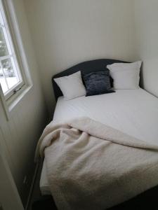 Lys og moderne leilighet i Bø.的床上有两张枕头,有毯子