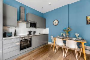 布莱顿霍夫☆☆☆ Brighton Lanes by Creatick ☆☆☆的厨房拥有蓝色的墙壁,配有桌椅