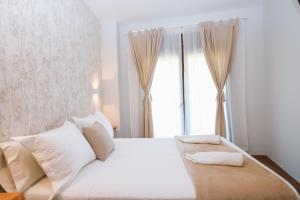 卡尔达斯·德·雷斯Villa Galicia的卧室配有白色的床和窗户。