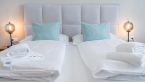 法克湖畔杜罗博拉赫Marienhof Apartments的一间卧室配有两张带毛巾的床