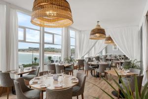 纽基菲斯特拉尔海滩酒店及Spa - 仅限成人入住的一间带桌椅的海景餐厅