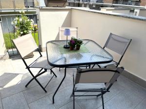 基瓦索Only Time- Luxury Comfort House的一张玻璃桌,两把椅子和一张桌子,上面有植物