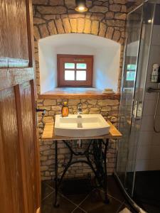 VidochovLittle Cottage No.100的一间带水槽和石墙的浴室
