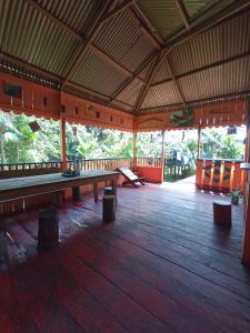 莱蒂西亚Hostal Búho Amazonas tours的一个带木地板和长凳的大型凉亭
