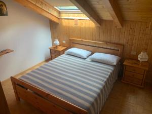 普雷达佐Appartamento Genziana的一间卧室配有一张带两个枕头的床