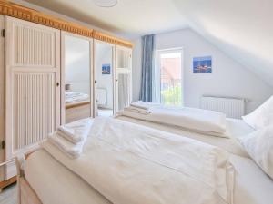 特希尔Küstenschwalbe的一间白色卧室,配有两张床和窗户