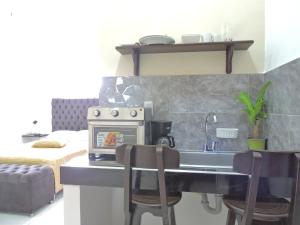 巴兰基亚Apartahotel Baq Suite 44的厨房配有炉灶和带椅子的盥洗盆。