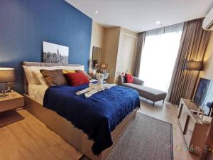 芭堤雅市中心Edge Central Pattaya by JJJ的一间卧室设有一张蓝色墙壁的大床
