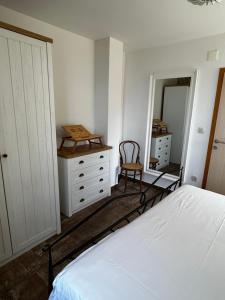 伯德古拉Stone house Kurtić stara Podgora的一间卧室配有一张床、梳妆台和椅子