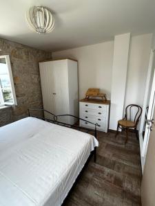 伯德古拉Stone house Kurtić stara Podgora的一间卧室配有一张床、一个橱柜和一把椅子