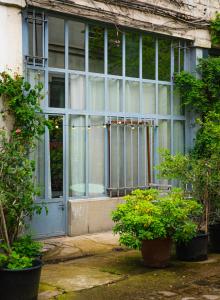 巴黎Le Garage的一座带蓝色门和一些植物的古老建筑