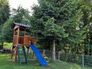 斯莫利亚纳茨米里亚娜宾馆的一个带蓝色滑梯和一棵树的游乐场