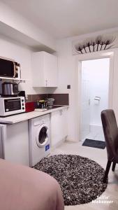 WoolwichStudio Flat, close to o2 Arena and City Airport的一间配备了微波炉和洗衣机的白色厨房