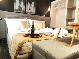 帕基诺Ti Scialíi Suites Rooms and Relax的一间卧室配有一张床和一瓶香槟