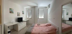 莫斯塔尔City Apartments的一间卧室配有一张床、一张书桌和一面镜子