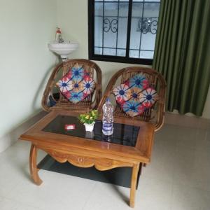 阿加尔塔拉Deep Home stay的两张藤椅和一张桌子,上面有一瓶