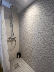 塔尔图Apartment Kvartsi的带淋浴的浴室(带瓷砖墙)