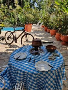 尼泰罗伊Andorinhas "Mini casa de hóspede"的蓝白的格子桌,带盘子和自行车