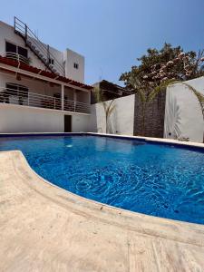 埃斯孔迪多港Residencia en el centro de Puerto Escondido的大楼前的大型蓝色游泳池