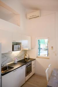 克勒克Holiday Home Laumar的厨房配有白色橱柜、水槽和窗户。
