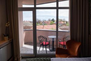 斯雷姆斯卡米特罗维察HOTEL GRACIAN的客房享有带椅子和桌子的阳台的景致。