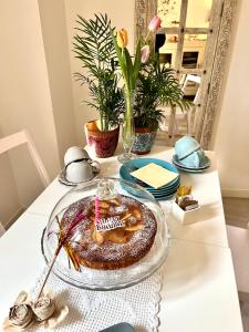 代森扎诺-德尔加达Residenza Elisa的一张桌子,上面有蛋糕,放在带蜡烛的玻璃盘上