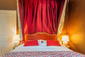 HuismesLes Jardins Haute Couture的一张带红色窗帘和两个红色枕头的床