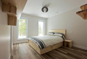 圣弗朗索瓦小河Le Vaillant du Massif的一间卧室设有一张床,天花板上设有时钟