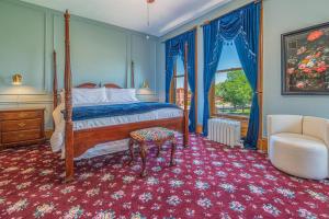 普韦布洛Orman Mansion - Pueblo's Most Luxurious Stay!的一间卧室配有一张床和一把椅子