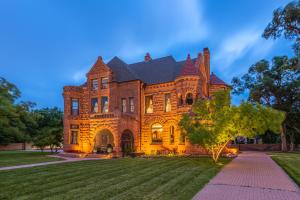 普韦布洛Orman Mansion - Pueblo's Most Luxurious Stay!的前面有一棵树的大砖房子