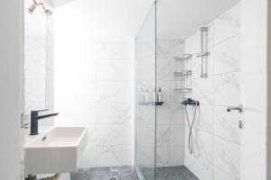 塞萨洛尼基Houseloft Bianca Vision的带淋浴和盥洗盆的白色浴室