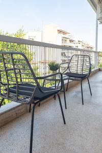 塞萨洛尼基Houseloft Bianca Vision的阳台上的两张黑长椅