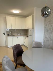 伊加洛Apartments City View的厨房配有白色的桌椅和白色的桌椅