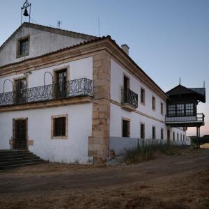 TerradillosCASA RURAL PALACIO CONDE DE ALDANA con piscina entre encinares y dehesas的一座古老的白色建筑,上面设有一个阳台