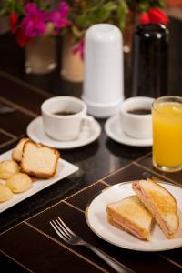 贝洛奥里藏特STATUS Motel的一张桌子,上面放有烤面包片、咖啡和橙汁