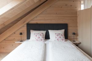 施瓦岑贝格Haus Hof 30的一间卧室配有两张带白色床单和红色枕头的床。