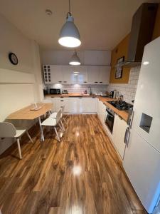 海伯敦桥Gorgeous home in Hebden Bridge的厨房铺有木地板,配有桌椅。