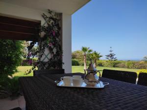 索维拉Villa Golf de Mogador - Piscine - Vue mer 180º的桌子上放着两个杯子和茶壶