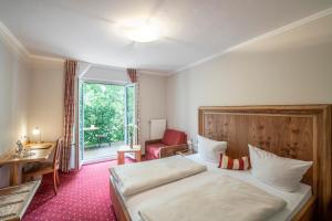 慕尼黑希尔朗格维尔德酒店的配有一张床、一张书桌和一扇窗户的酒店客房
