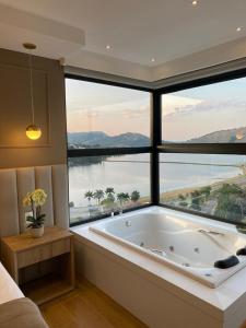 卡皮托利乌Vista do Lago Hotel的大型浴室设有带浴缸的大窗户