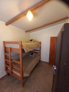 圣佩德罗·德·阿塔卡马Casa Sutar Las Higueras的小房间设有两张双层床和一台冰箱