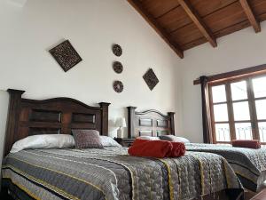 危地马拉安地瓜Casa Los Habitantes Antigua Guatemala的一间卧室设有两张床和窗户。