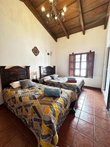 危地马拉安地瓜Casa Los Habitantes Antigua Guatemala的一间卧室设有两张床和天花板
