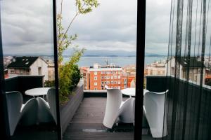 桑坦德Hotel Art Santander的市景阳台配有桌椅。