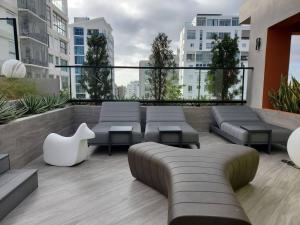 圣多明各Acogedor Apartamento - Regatta Living 2的一座大楼内一个带沙发和桌子的屋顶露台
