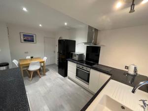 BurscoughIdyllic bungalow, ideal location in West Lancashire的厨房配有黑色冰箱和桌子