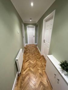 BurscoughIdyllic bungalow, ideal location in West Lancashire的走廊设有两扇白色门,铺有木地板